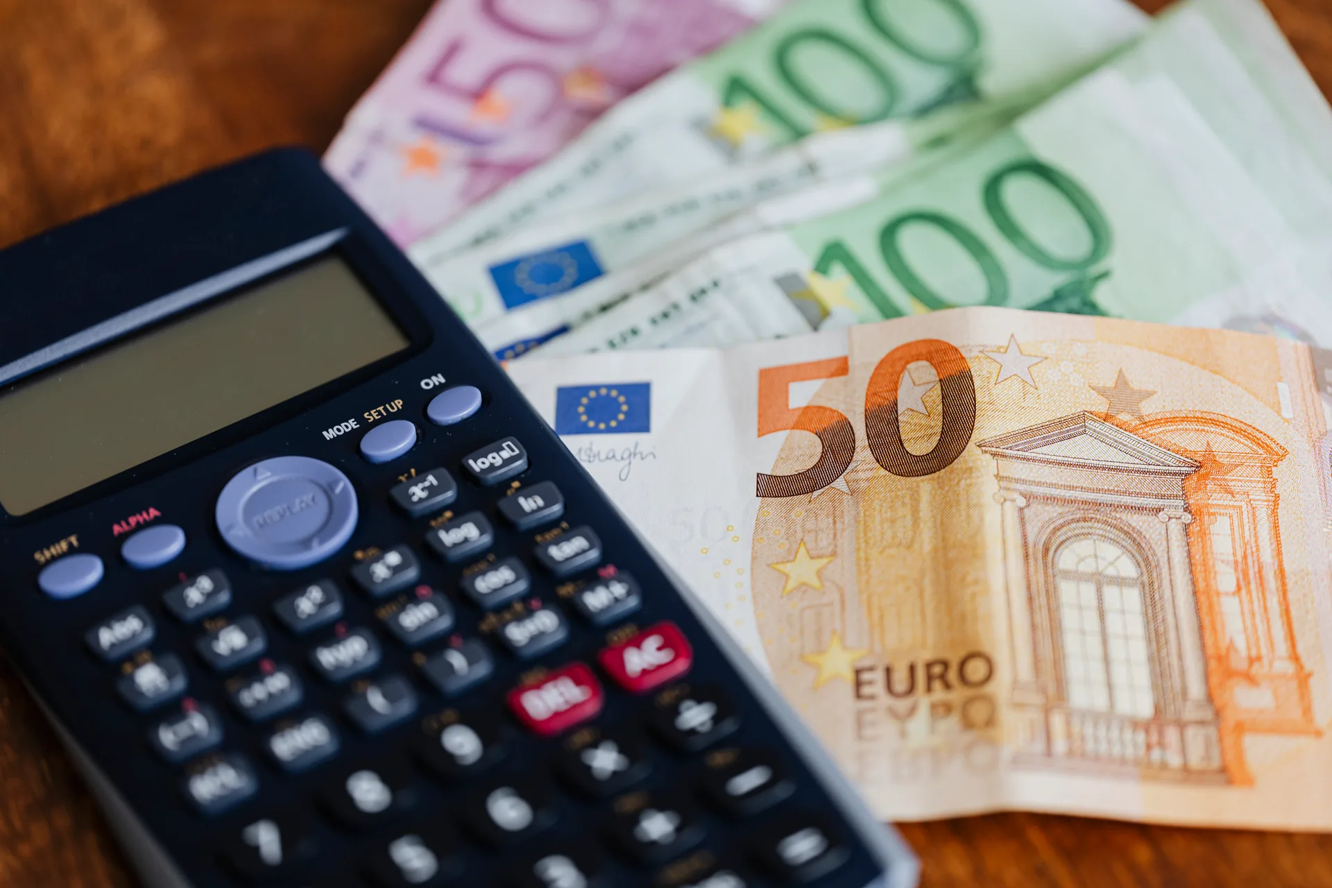 Euro banknotes and calculator used to compare rental yields