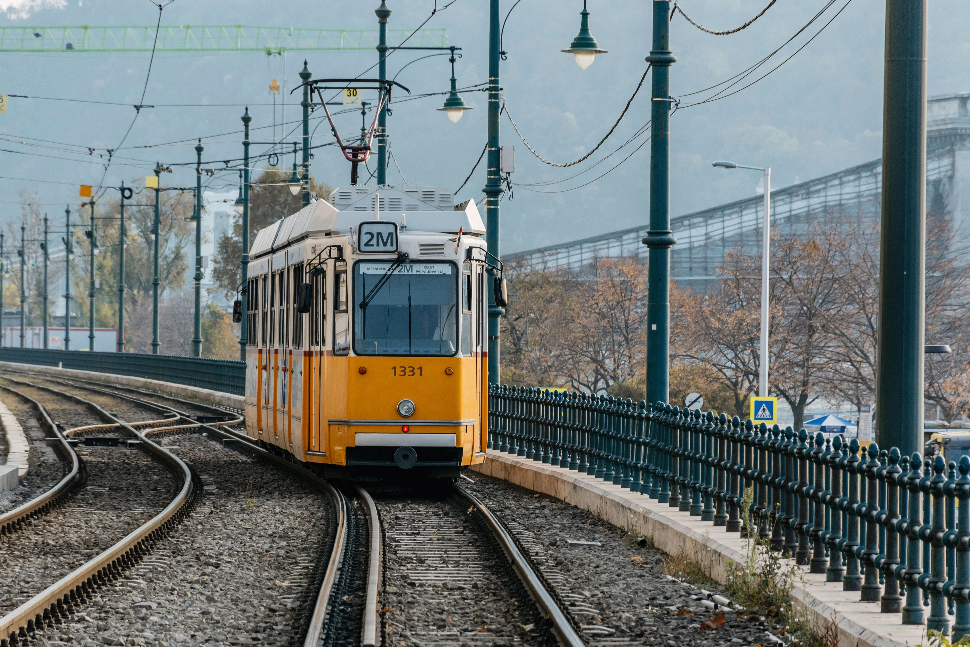 Straßenbahn fährt neben Wohngebieten in Budapest am Donauufer